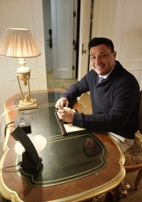 A man sitting at a table with a phone.