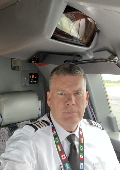 A man in uniform sitting inside of a car.